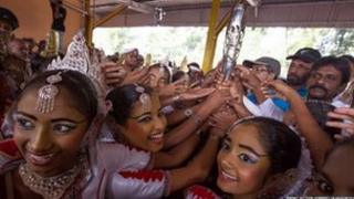 Dawnswyr traddodiadol yn Sri Lanka yn dathlu gyda'r baton.