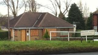 Boarded up windows at the house