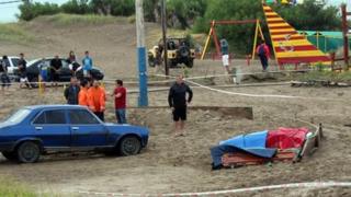 People remain near a corpse after a lightning killed three tourists in Villa Gesell, Argentina on January 9, 2014