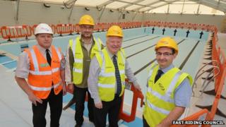 Contractors and councillors gather around the pool