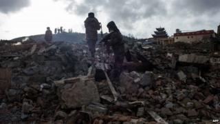 This picture taken on 12 January 2014 shows rescuers working on the wreckage of damaged houses in an ancient Tibetan town of Gyalthang, known in Chinese as Dukezong, in Shangri-La, southwest China's Yunnan province after a fire flattened two thirds of the town's old centre