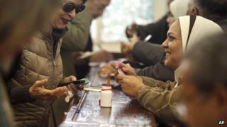 An election worker checks the identification of a woman at a polling site in Cairo