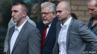 Rolf Harris (centre, with red tie) outside Southwark Crown Court on 14 January 2014