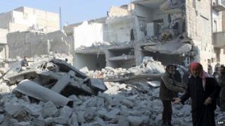 Syrians inspect damaged buildings in Aleppo. Photo: 18 January 2014