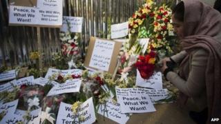 Afghan activists pay tribute to the victims of an attack two days ago, in front of the restaurant on 19 January 2014