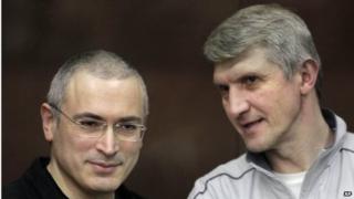 Платон Лебедев (справа) и Михаил Ходорковский (слева) беседуют за стеклянным ограждением в зале суда в Москве, Россия, 30 декабря 2010 года.