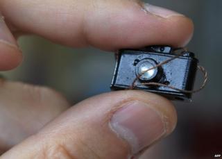 Man holds tiny model camera