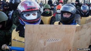 Protesters wield makeshift shields and wear motorcycle helmets in preparation for confrontation with riot police in Kiev on January 29, 2014
