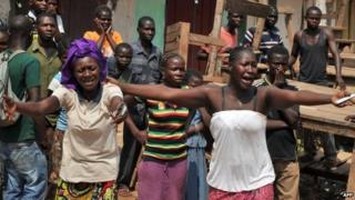 The wife and sister of a Christian man killed by anti-Balaka combatants after he was mistaken for a Muslim react as his body (not pictured) is transported on a cart in Bangui on 29 January 2014