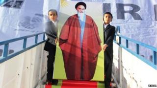 Khomeini's likeness in front of a painted backdrop of an Air France jet