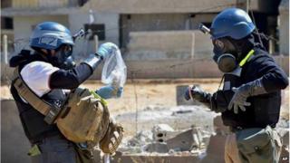 Investigators take samples of sand near a part of a missile that was suspected of carrying chemical agents, at a site near Damascus in August 2013