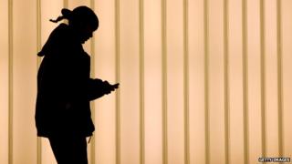 Женщина использует смартфон от Всемирного торгового центра, Нью-Йорк