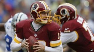 Washington Redskins quarterback Kirk Cousins looks for an opening to pass during the first half of an NFL football game against the Dallas Cowboys in Landover, Maryland, on 22 December 2013