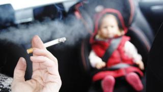 Child in a car with an adult smoking