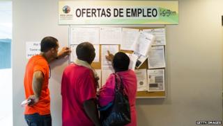 Puerto Ricans looking at an employment board