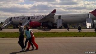 Passengers disembark the plane