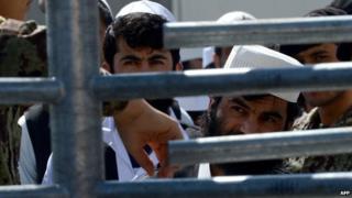 Afghan detainees wait to be released during a ceremony to hand over Bagram prison to the Afghanistan government at Bagram Prison facilities on 25 March 2013.