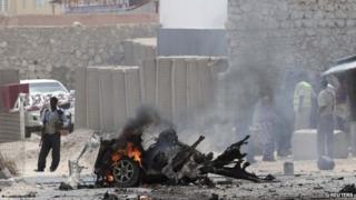 Security personnel gather at the scene of an explosion near the entrance of the airport in Somalia's capital Mogadishu -13 February 2014