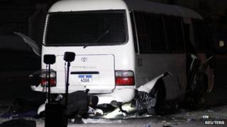 A police special unit inspects the police patrol mini bus which was hit by explosions at a police checkpoint in the village of Dih