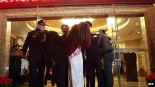 Chinese policemen arrest suspected prostitutes in Dongguan