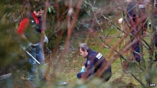 Police use metal detectors to search a garden