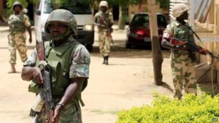 Nigerian soldiers stand guard at the offices of the state-run Nigerian Television Authority in Maiduguri, Nigeria on 6 June 2013