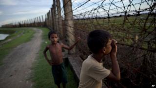 Фото из архива: Мальчик-мусульманин смотрит через забор из колючей проволоки на границе Мьянмы и Бангладеш в Маундо, штат Ракхайн, Мьянма, 11 сентября 2013 г.
