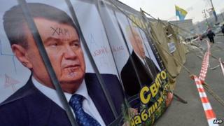 A placard depicting Ukraine's then President Viktor Yanukovych and Prime Minister Mykola Azarov behind prison bars at the protesters' camp in Maidan (Independence) Square in Kiev on 27 December 2013
