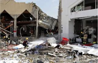 A fire fighter sprays the site at a Turkish restaurant following a suspected gas explosion in Doha