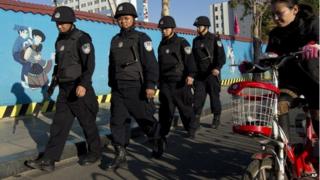 Вооруженные полицейские патрулируют на улице возле железнодорожного вокзала Куньмин в провинции Юньнань на западе Китая, 3 марта 2014 года