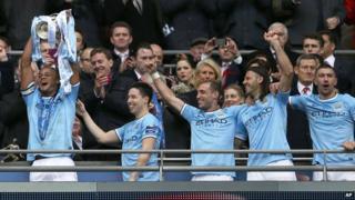 Manchester City players celebrate with Capital One trophy