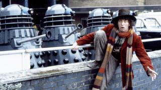 Tom Baker as the Doctor, with Daleks in TV Centre car park