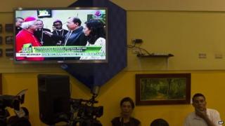 A TV screen shows live coverage of Nicaragua's President Daniel Ortega (centre) and his wife Rosario Murillo welcoming home Nicaragua's newly-appointed Cardinal Leopoldo Brenes