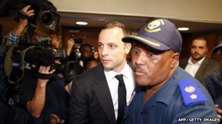 South African Paralympian star Oscar Pistorius (2nd L) leaves the court after the first day of his trial on March 3, 2014 in Pretoria.
