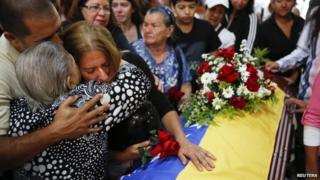 Relatives of Jimmy Vargas, a student who died during a protest, stand next to his coffin during his funeral in San Cristobal on 26 February, 2014