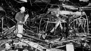 A fireman hoses down smouldered debris inside the Debenhams store at Luton, Befordshire