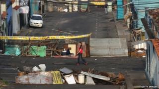 A woman walks past barricades in San Cristobal on 8 March, 2014