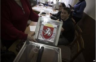 A Ukrainian election official holds a ballot box during preparations for Sunday's referendum at a polling station in Simferopol, Ukraine, March 15