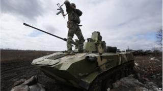 A Ukrainian soldier stands on an armoured vehicle at a military camp near the village of Michurino, Ukraine, 17 March 2014