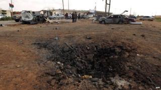 A crater scars the earth after a car bomb targeting a military academy in Libya's restive eastern city of Benghazi detonated on March 17, 2014, killing at least five soldiers and wounded more than 10, military and hospital sources said.