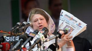 Khaleda Zia holds a Bengali newspaper while addressing a rally in Dhaka on January 20, 2014.