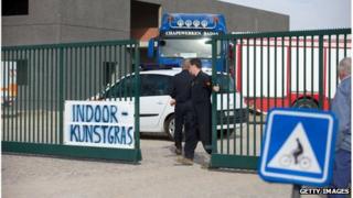 A man closes the gate to an industrial site where a World War One shell exploded during excavation works