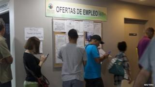 People line up at an unemployment office of the Labor Department in San Juan March 13, 2014.