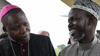 Bangui's archibishop Dieudonne Nzapalainga (L) talks with President of the Muslim community of Central Africa Imam Omar Rabine Layama (R) upon their arrival at Bangassou airport, on October 8, 2013 in Bangassou, to meet members of the Christian and Muslim communities after a week of tension