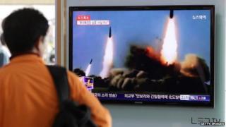 Man watches TV broadcast of North Korean missile launches. 26 March 2014