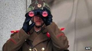 A North Korean soldier looks on at the South side at the truce village of Panmunjom in the Demilitarised Zone dividing the two Koreas on 12 March 2014