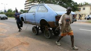 Two men push a car in a street of Accra, Ghana on 2 June 2007