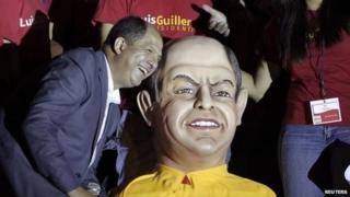 Luis Guillermo Solis poses next to a figure of himself before delivering a speech at a rally after official election results were released in San Jose on 6 April, 2014