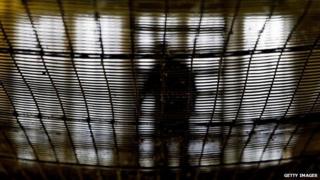 A prisoner at HMP Pentonville walks through an atrium May 19, 2003 in London