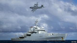 Самолет RAAF AP-3C Orion пролетает мимо британского военного корабля HMS Echo в Индийском океане и продолжает поиск пропавшего рейса Malaysia Airlines MH370 - 15 апреля 2014 года